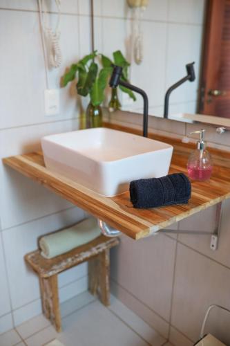 a white sink on a wooden shelf in a bathroom at Mareias Villas in São Miguel do Gostoso