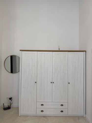 a white cabinet in a room with a mirror at Студія біля Прикордонної Академії in Khmelnytskyi