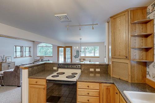 a large kitchen with a stove and a sink at Riverfront Retreat in Sagle