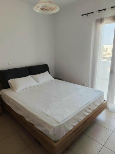 a bedroom with a large bed with white sheets at NaxosChoraNext in Galanádhon