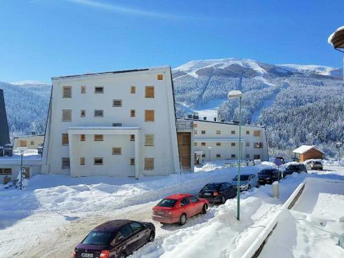 a group of cars parked in the snow in front of a building at Apartment Hobbit - Bjelašnica in Bjelašnica