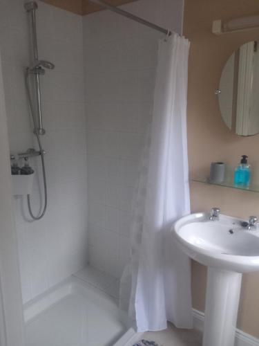 a bathroom with a white shower curtain and a sink at Waterways Lodge in Carrick on Shannon