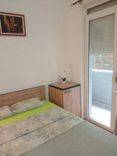 a bedroom with a bed and a window at Apartman Apatin studio DUE in Apatin