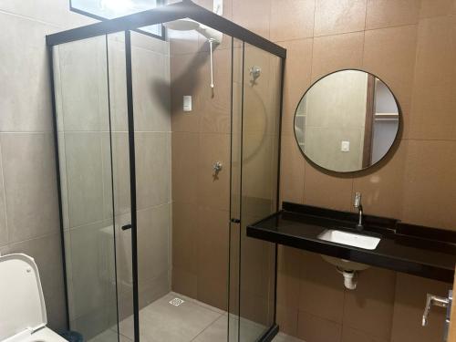 a bathroom with a shower and a sink and a mirror at Prime Pousada - Posto Sudoeste Queimadas in Queimadas