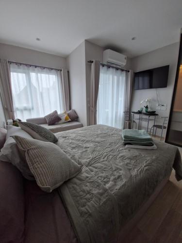 a bedroom with a large bed and a couch at Serenity Naiyang Най Янг D02 in Nai Yang Beach