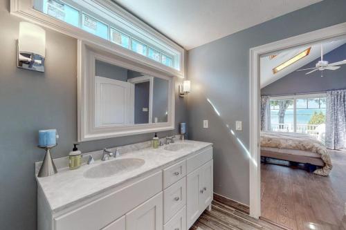 a bathroom with a sink and a mirror and a window at 4 Bed 2 Bath Vacation home in Ossipee in Ossipee
