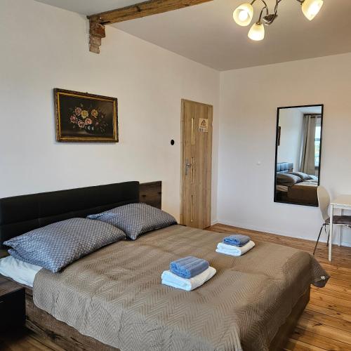 a bedroom with a bed with two towels on it at Kamienica Nowodworska 30 in Bydgoszcz