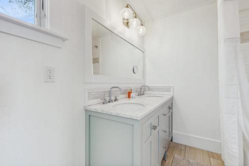 a white bathroom with a sink and a mirror at Wallis Sands Beach Serenity in Rye