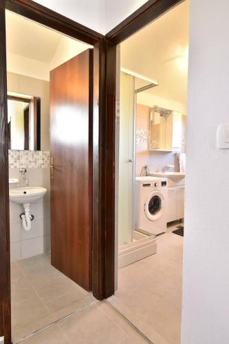 a bathroom with a sink and a washing machine at Villa Natali in Pridraga