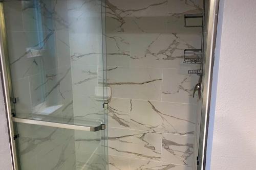 a bathroom with a shower with a glass door at Tiny Lake Retreat in Sagle