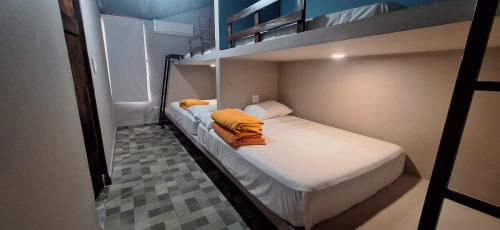 a bedroom with a bunk bed with white sheets and orange blankets at Stone Hill farm & cabins in Penonomé