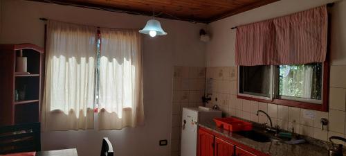 a kitchen with a window and a sink and a refrigerator at Luna Plateada - Terrafirme in Villa Yacanto