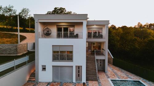 a white house with two balconies and a staircase at Villa Dubrava in Matuzići