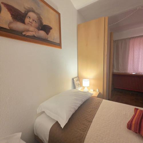a bedroom with a bed with a angel picture on the wall at L'Albore in Costigliole Saluzzo