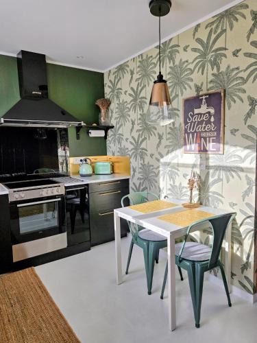 a kitchen with a table and a stove top oven at Maison Finchette pour 2 - 5 min Saint-Émilion - Terrasse privée - Parking - Arrivée autonome in Sainte-Terre