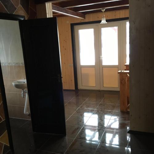 a bathroom with a door and a sink in a room at Сонячний in Slavske