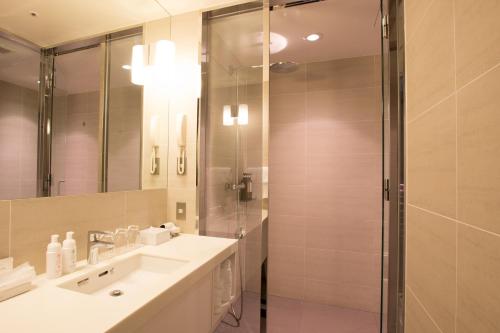 a bathroom with a shower and a sink and a mirror at The Gate Hotel Kaminarimon by Hulic in Tokyo