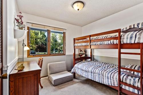 a bedroom with two bunk beds and a desk and a desk at Sandpoint Paradise in Sandpoint