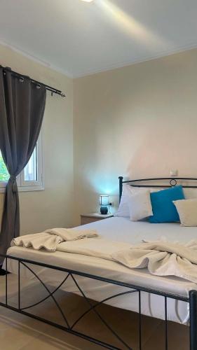 a bedroom with a large bed with blue pillows at Casa di Nonno in Alikanas