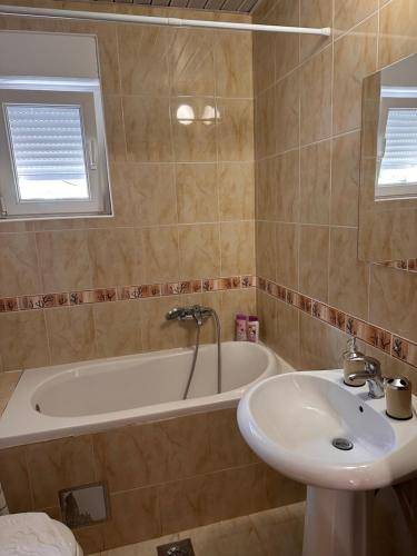 a bathroom with a sink and a bath tub at Sirius Apartment in Škaljari
