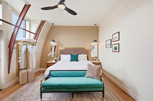 a bedroom with a bed and a green bench at The Q Inn in Morro Bay