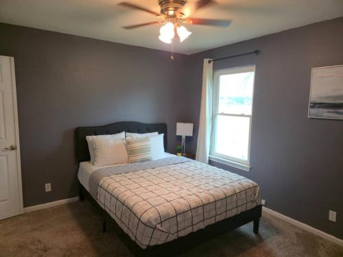 a bedroom with a bed with a ceiling fan and a window at Lakefront Retreat, Pool, Hottub, Firepit in Azle