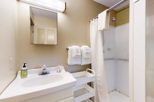 a white bathroom with a sink and a shower at The Mitchell House in North Woodstock