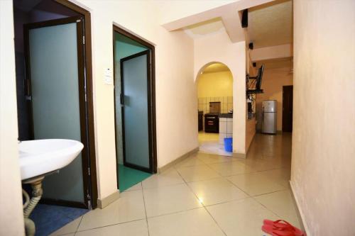 a bathroom with two doors and a sink in it at Barizi Cottage in Tulu