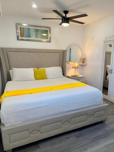 a bedroom with a large bed with a ceiling fan at Private Cozy Studio in Sunrise