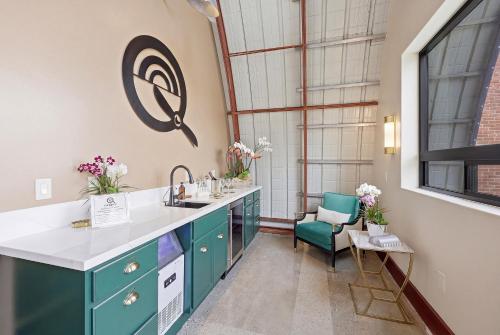 a kitchen with blue cabinets and a sink and a chair at The Q Inn in Morro Bay