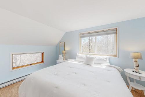 a white bedroom with a large bed and a window at South Village #49 in Warren
