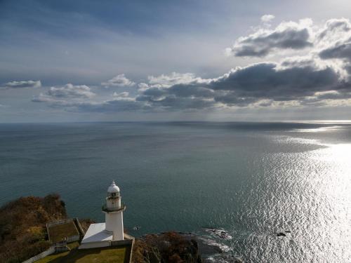 a lighthouse sitting on top of a cliff next to the ocean at Muroran Prince Hotel in Muroran