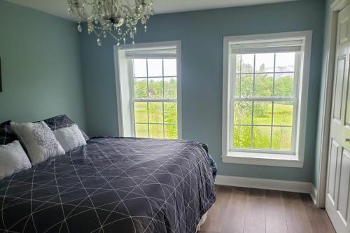 ein Schlafzimmer mit einem Bett und zwei Fenstern in der Unterkunft Vibrant Views in Ludlow