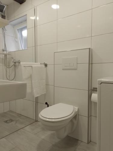 a white bathroom with a toilet and a sink at Studios Ciao Bella city centre with free parking in Šibenik