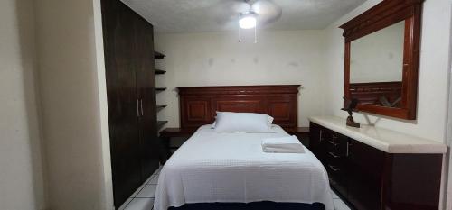 a small bedroom with a bed and a mirror at Loft Armonía in Jardines del Valle in Guadalajara