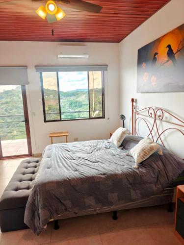 a bedroom with a bed and a large window at Altura & lago in San Nicolás