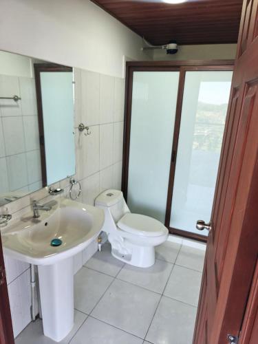 a bathroom with a sink and a toilet at Altura & lago in San Nicolás