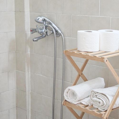 a shower in a bathroom with towels on a shelf at Chrysanthi Melitsa apts. in Sidari