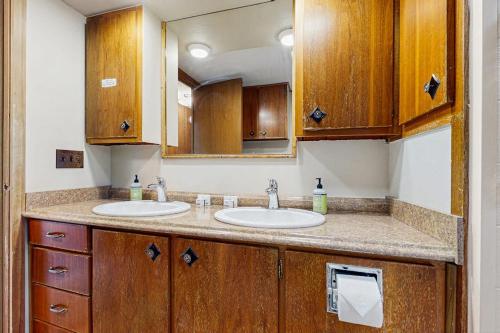 a bathroom with two sinks and a mirror at Riverbank's Pemi Cottage in Lincoln