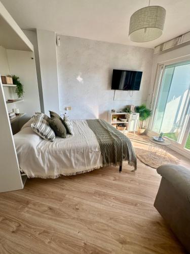 a bedroom with a bed and a large window at Oasis de Málaga in Chilches