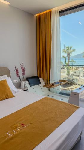 a bedroom with a bed with a view of the ocean at TreA Suites By Aria in Vlorë