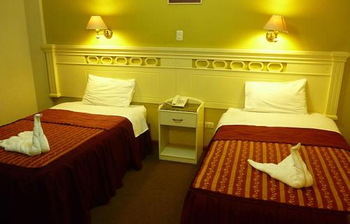 Habitación de hotel con 2 camas y teléfono en Hotel San Martín, en Tacna