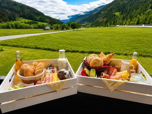 two containers filled with bread and vegetables next to a field at Ski Vital Apartments in Sankt Michael im Lungau