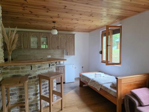 a kitchen with wooden ceilings and a table in a room at Vila Montana in Dobrilovina