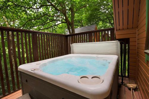 a hot tub on the deck of a house at Lodge Nine for 6 with Hot Tub - Spa Resort in Devon in Chudleigh