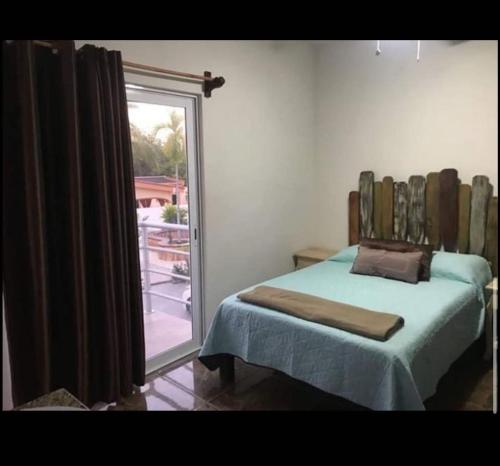a bedroom with a bed and a large window at Mar Real Suites Guayabitos in Rincon de Guayabitos