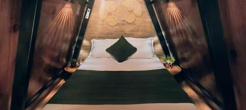 a bed in a room with two plants at Cabana da Lua Chalés Vero Verde in Serra Negra