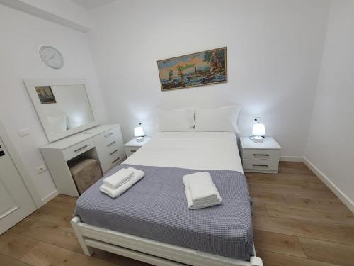 a bedroom with a bed with two towels on it at Vila Mollanji in Tirana