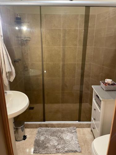 a bathroom with a shower with a sink and a toilet at BeM Ipanema in Rio de Janeiro