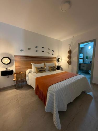 a bedroom with a large bed and a clock on the wall at Alojamientos LUMARA in Peal de Becerro